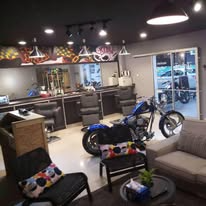Real photo of Joker's Barbershop's interior — a motorcycle parked between the barber stations