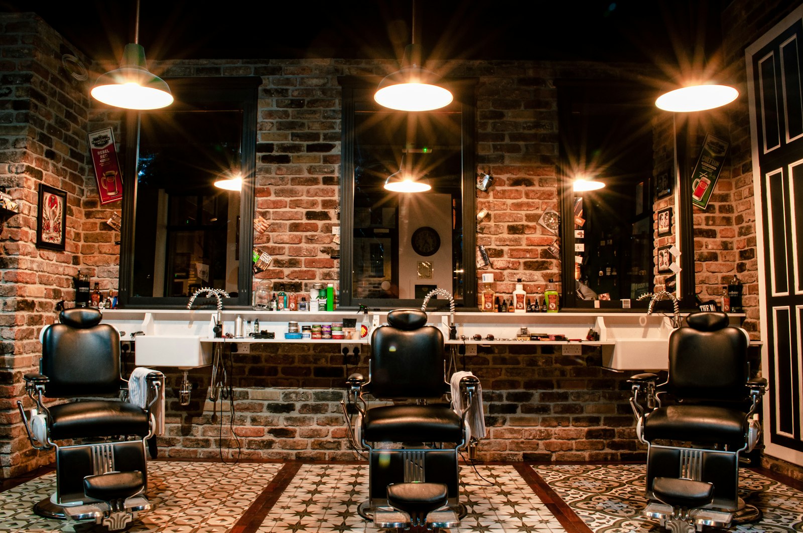 Stand-in Unsplash photo of a moody exposed-brick barbershop with three barber chairs — real Joker's Barbershop interior photo to be swapped in once available