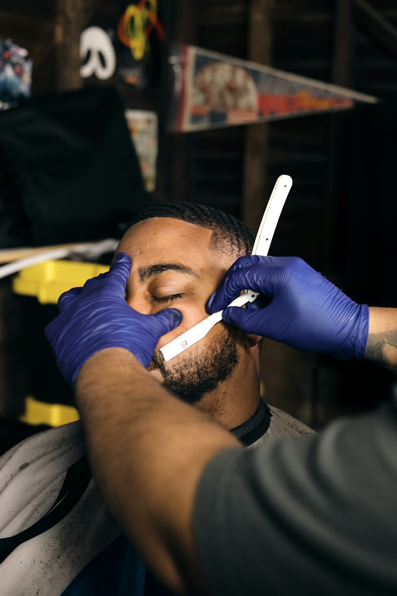 Stand-in Unsplash photo of a barber giving a hot-towel shave with a straight razor — real Joker's Barbershop photo to be swapped in once available