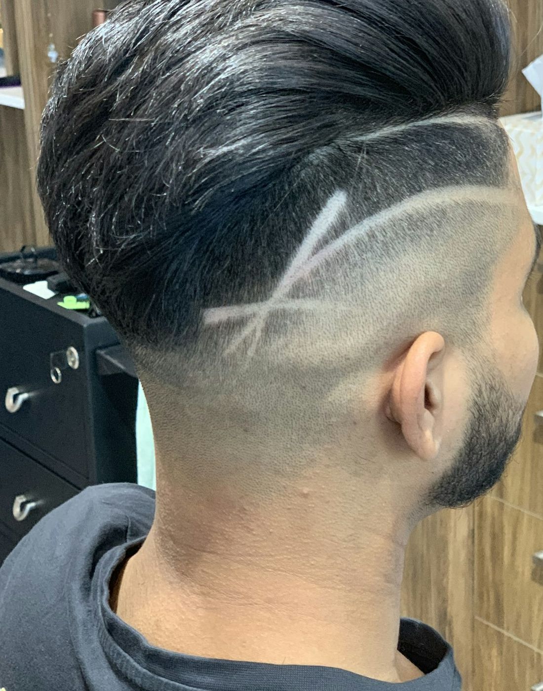 Stand-in Unsplash photo of a skin fade with freehand lines and a crossed design cut into the side